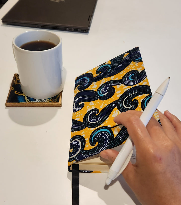 mental health journal with yellow and blue cover next to cup of coffee