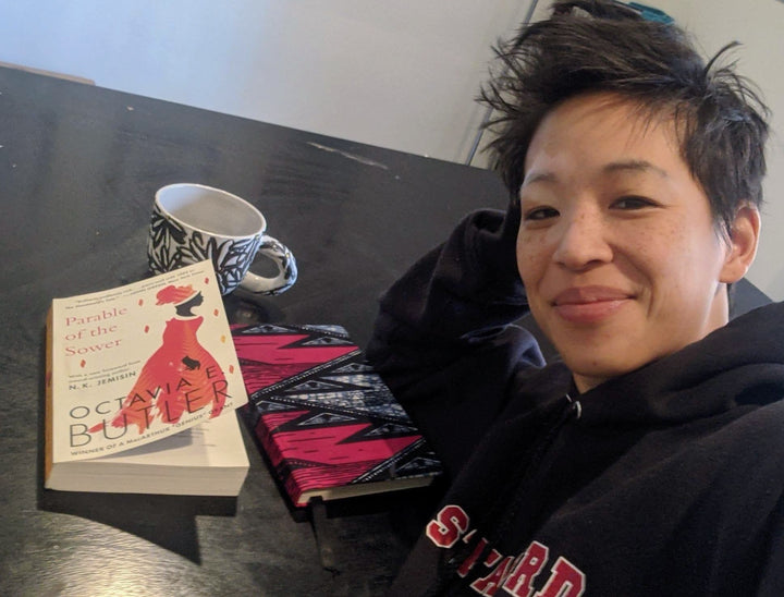 alina with custom wellness journal and book and coffee, doing self care journaling