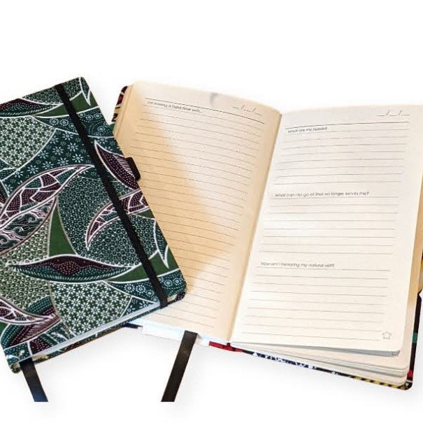 healing journal for self care journaling by zenit, one closed with green batik fabric print cover, one open with healing prompts